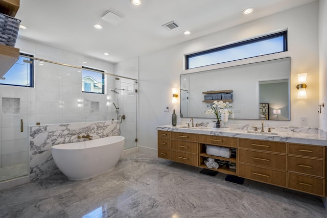 bathroom with a sink, visible vents, a freestanding bath, a shower stall, and double vanity