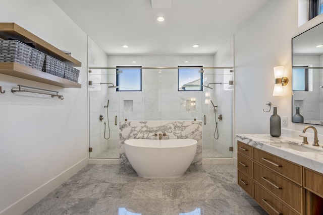 bathroom featuring marble finish floor, a soaking tub, vanity, and a shower stall