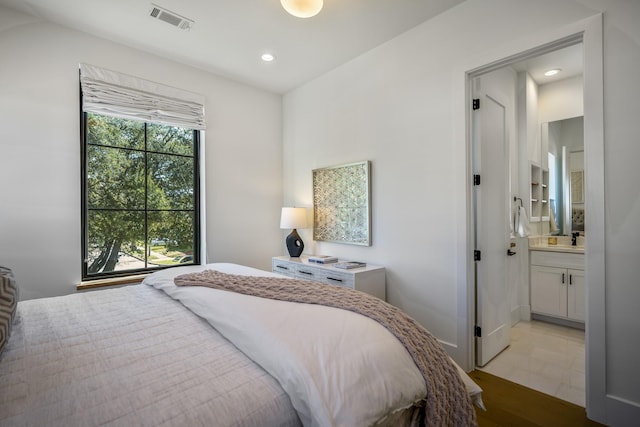 bedroom featuring ensuite bath, visible vents, and recessed lighting