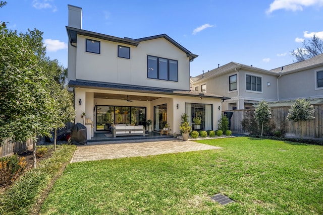 rear view of house featuring ceiling fan, a patio, a fenced backyard, an outdoor living space, and a yard