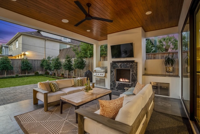 view of patio featuring grilling area, an outdoor living space with a fireplace, area for grilling, a ceiling fan, and a fenced backyard