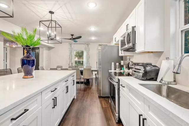 kitchen with light countertops, appliances with stainless steel finishes, a sink, and white cabinets