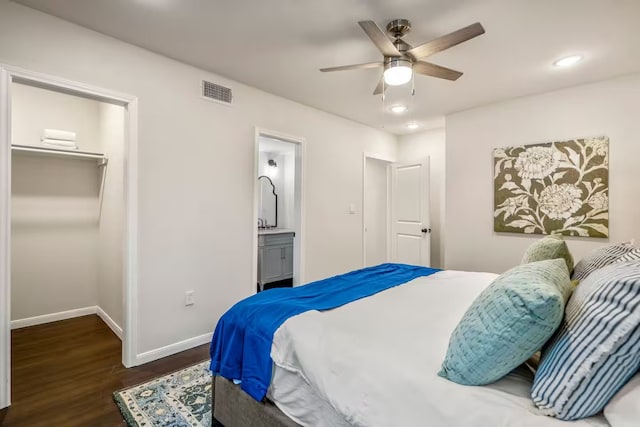 bedroom with visible vents, baseboards, a closet, dark wood-style floors, and a walk in closet