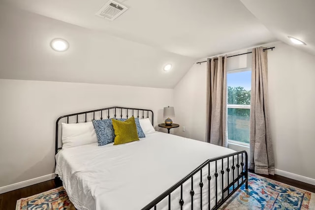 bedroom with lofted ceiling, baseboards, visible vents, and dark wood-style flooring