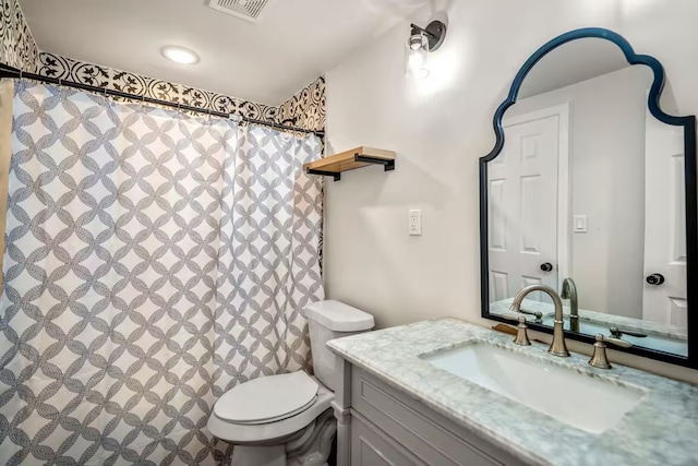 bathroom with toilet, visible vents, a shower with shower curtain, and vanity