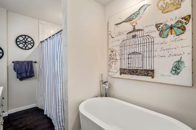 bathroom featuring a soaking tub, baseboards, wood finished floors, and a shower with shower curtain