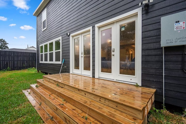 deck with a yard, fence, and french doors