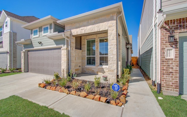 view of front of home featuring a garage, stone siding, and concrete driveway