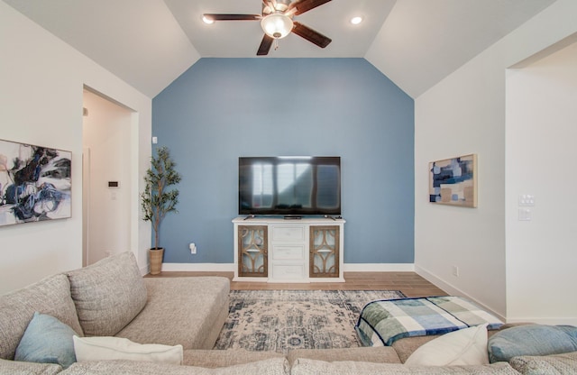 living room featuring a ceiling fan, lofted ceiling, baseboards, and wood finished floors