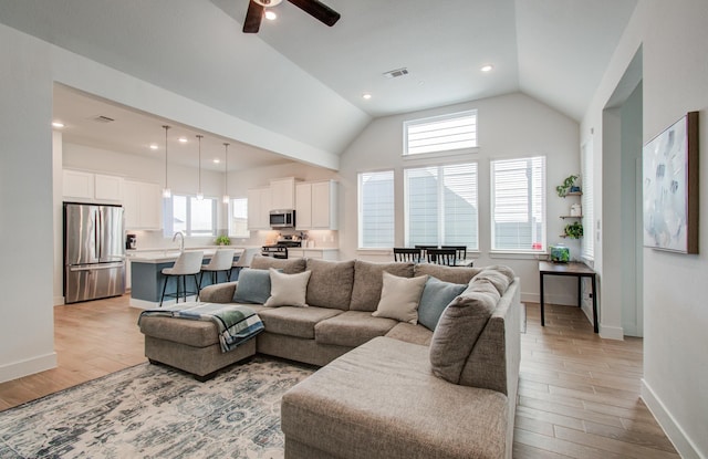 living area with lofted ceiling, recessed lighting, visible vents, light wood-style floors, and baseboards