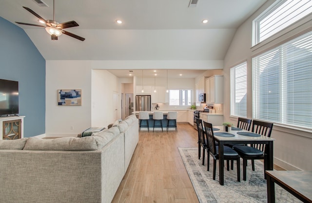 living room with light wood finished floors, ceiling fan, vaulted ceiling, and recessed lighting