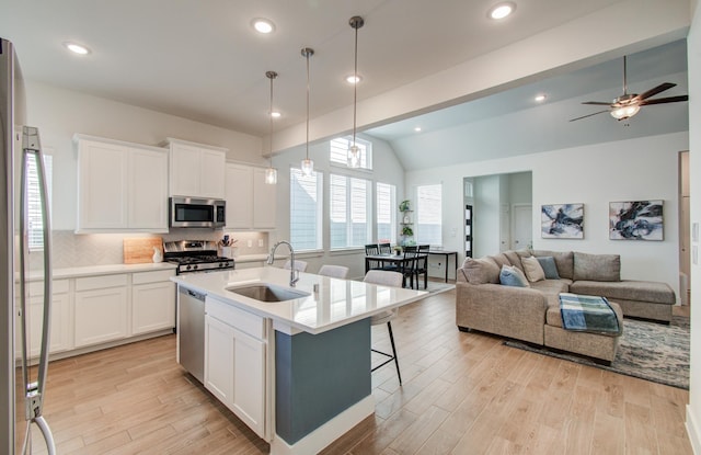 kitchen featuring appliances with stainless steel finishes, light countertops, a sink, and white cabinetry