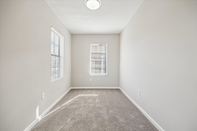 empty room featuring carpet floors and baseboards
