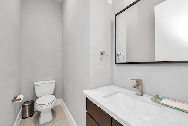 half bath with toilet, baseboards, vanity, and tile patterned floors