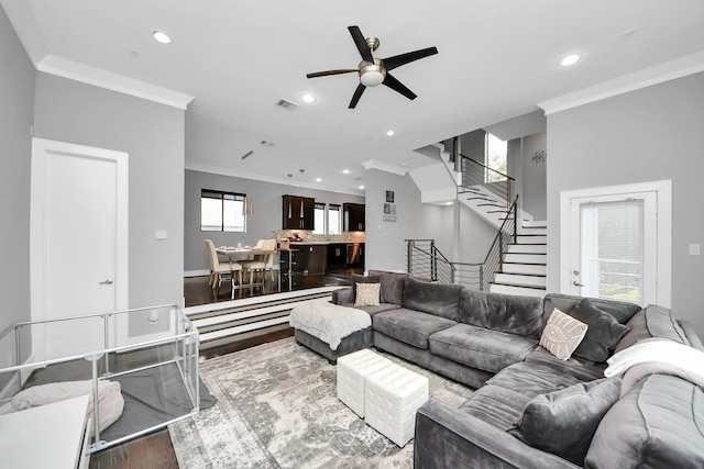 living area featuring recessed lighting, wood finished floors, visible vents, stairway, and crown molding