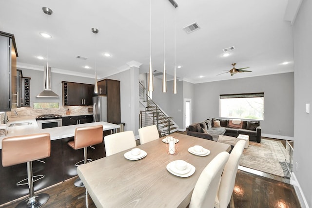 dining area with stairway, visible vents, ornamental molding, and dark wood-style flooring