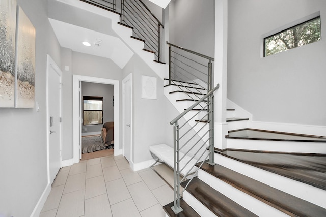 staircase featuring tile patterned flooring and baseboards