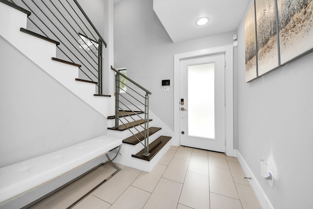 entrance foyer with stairs and baseboards