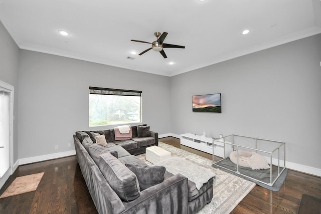 living room with crown molding, dark wood-type flooring, visible vents, and baseboards