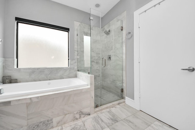 bathroom featuring a garden tub, a shower stall, and marble finish floor