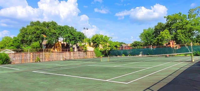 view of tennis court featuring fence