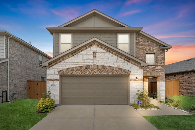 view of front facade with an attached garage, fence, concrete driveway, a gate, and a front yard