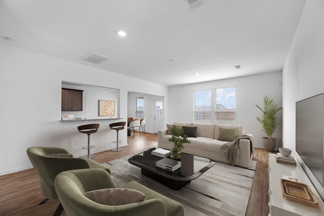 living room featuring recessed lighting, visible vents, light wood-style flooring, and baseboards