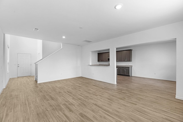 unfurnished living room featuring baseboards, recessed lighting, visible vents, and light wood-style floors