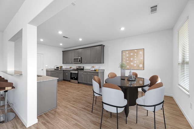 dining room with light wood-style floors, recessed lighting, visible vents, and baseboards