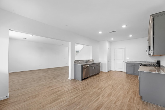 kitchen with appliances with stainless steel finishes, light stone counters, gray cabinets, light wood-style floors, and recessed lighting