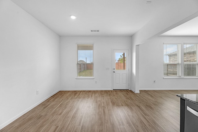 foyer entrance featuring light wood-style flooring, plenty of natural light, and visible vents