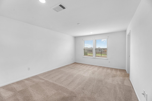 empty room featuring recessed lighting, visible vents, light carpet, and baseboards