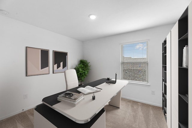 office area featuring light carpet and baseboards