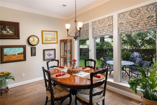 dining space featuring ornamental molding, wood finished floors, visible vents, and an inviting chandelier