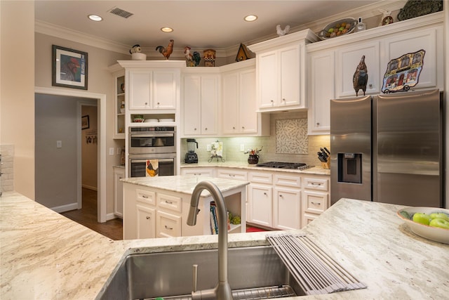 kitchen featuring stainless steel appliances, visible vents, white cabinets, decorative backsplash, and crown molding