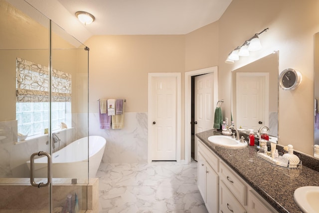 full bath with a sink, marble finish floor, a soaking tub, double vanity, and a stall shower