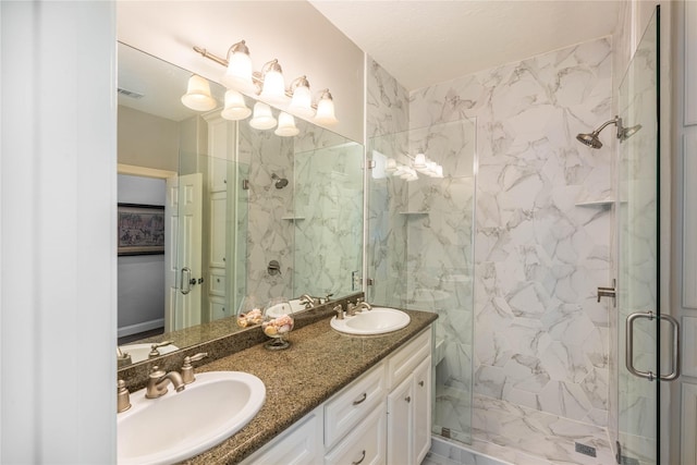 full bath featuring visible vents, double vanity, a sink, and a marble finish shower