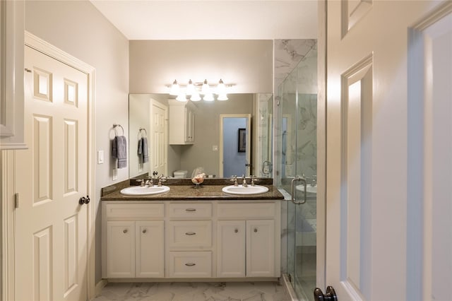 full bath featuring double vanity, marble finish floor, a marble finish shower, and a sink