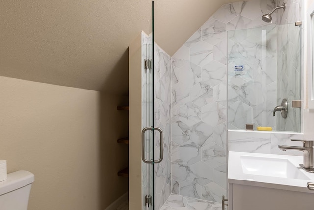 bathroom featuring lofted ceiling, vanity, a marble finish shower, and toilet