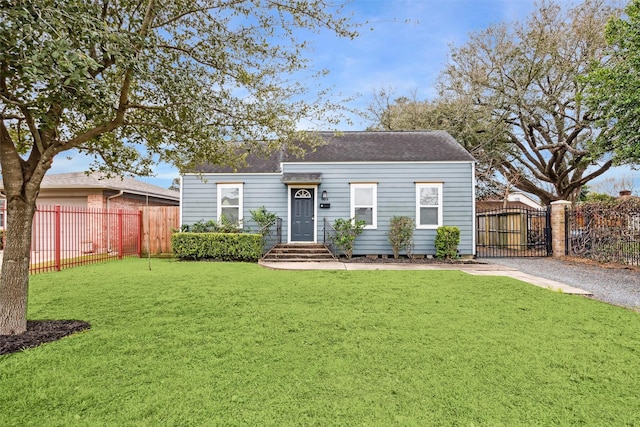 view of front facade with a gate, roof with shingles, fence, and a front lawn