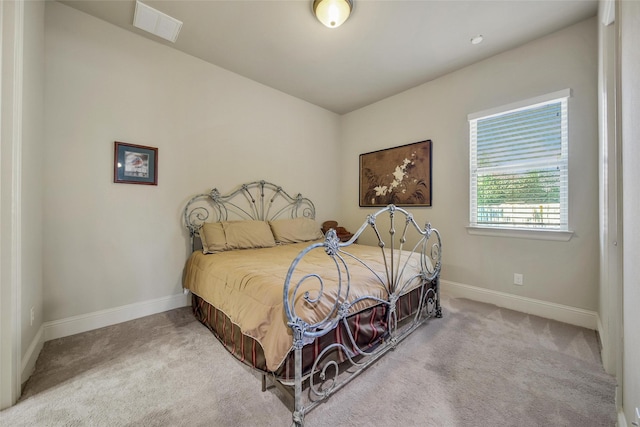 carpeted bedroom with visible vents and baseboards