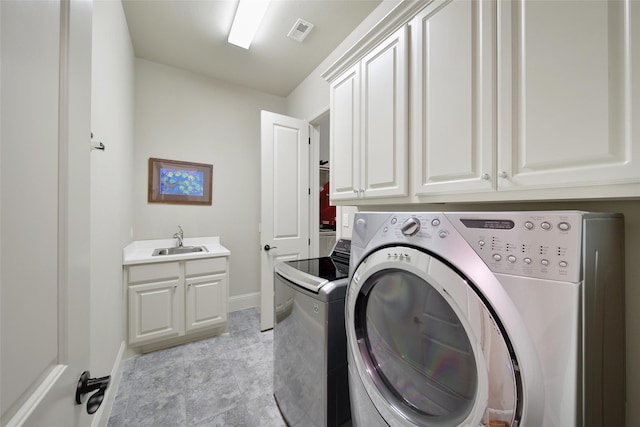 washroom featuring cabinet space, visible vents, a sink, independent washer and dryer, and baseboards