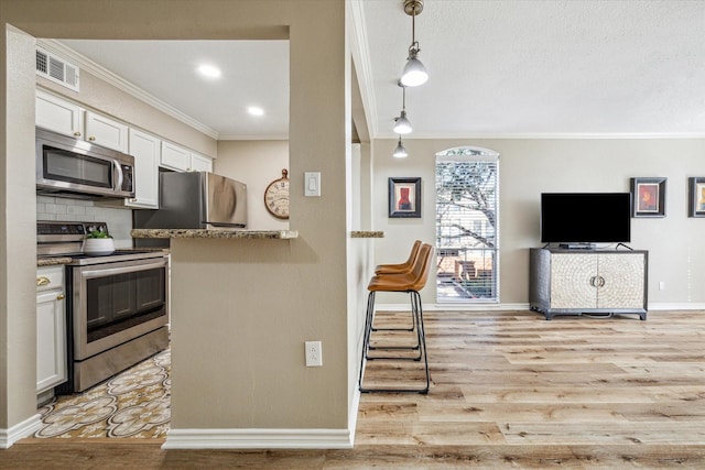 kitchen with light stone counters, stainless steel appliances, visible vents, white cabinetry, and hanging light fixtures