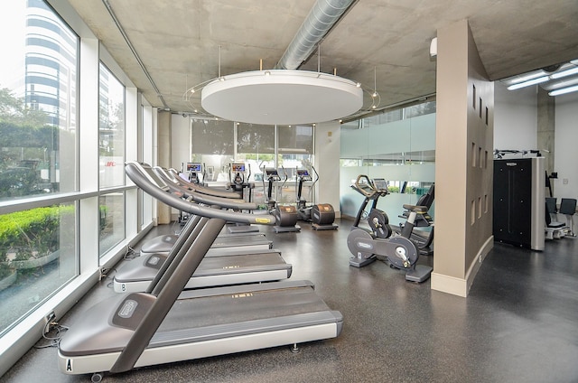 workout area featuring floor to ceiling windows and baseboards