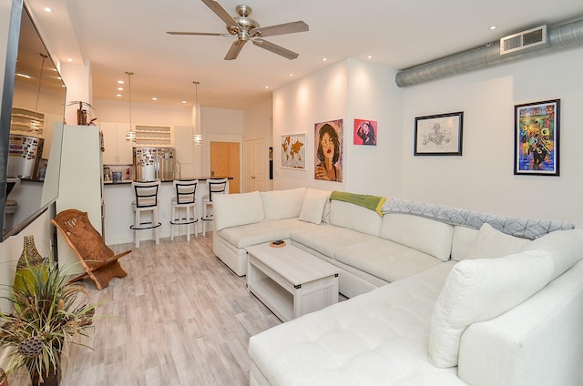 living room with ceiling fan, recessed lighting, visible vents, and light wood-style floors