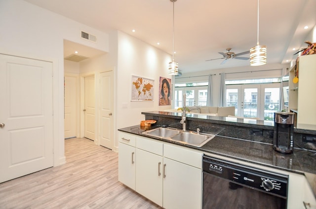 kitchen featuring light wood finished floors, visible vents, white cabinets, dishwasher, and a sink