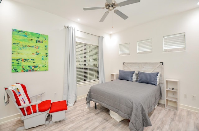 bedroom featuring a ceiling fan, light wood-type flooring, and baseboards