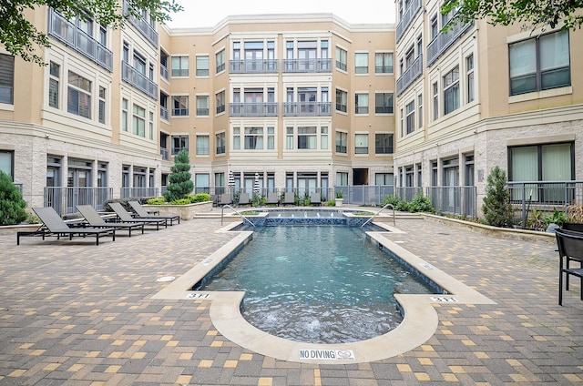 view of swimming pool featuring fence and a patio