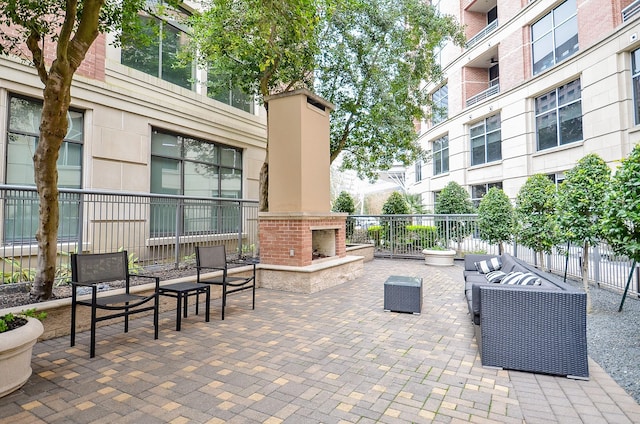 view of patio featuring an outdoor living space with a fireplace and fence