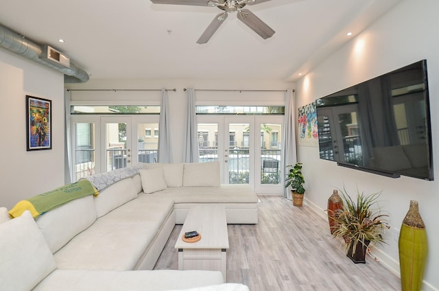 living room featuring a ceiling fan, plenty of natural light, baseboards, and wood finished floors